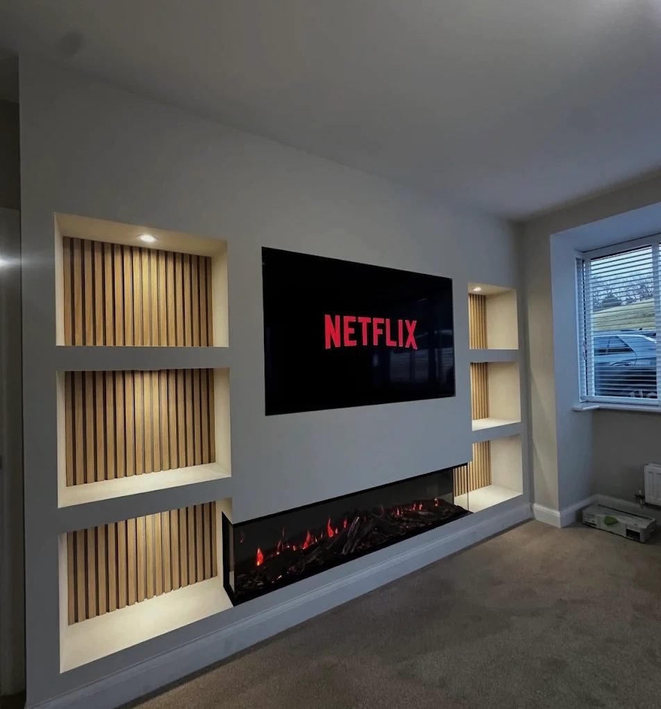Finished media wall with slatted recesses, mounted TV and electric fire